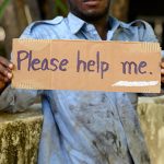 Portrait of young homeless African man on the bridge in the streets outdoors
